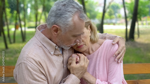 Old husband embracing ill wife, love until old age, support, care, togetherness photo
