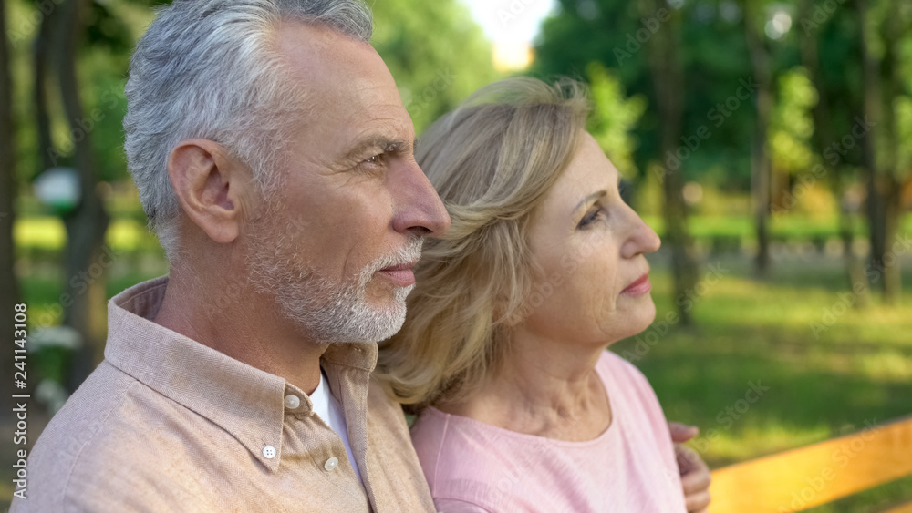 Male and female pensioners watching sunset together park, enjoying nature view Male and female pensioners watching sunset together park, enjoying nature view