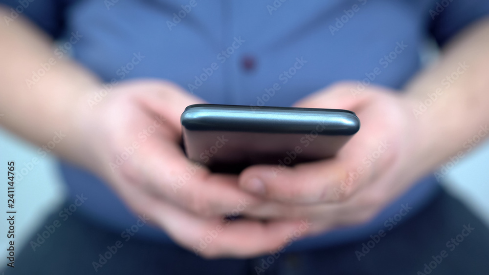 Male hands using smartphone close up, searching for diet application, addiction Male hands using smartphone close up, searching for diet application, addiction
