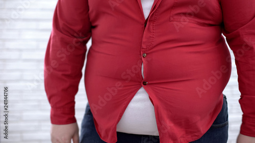 Obese man wearing tight red shirt, oversize clothing problem, insecurities