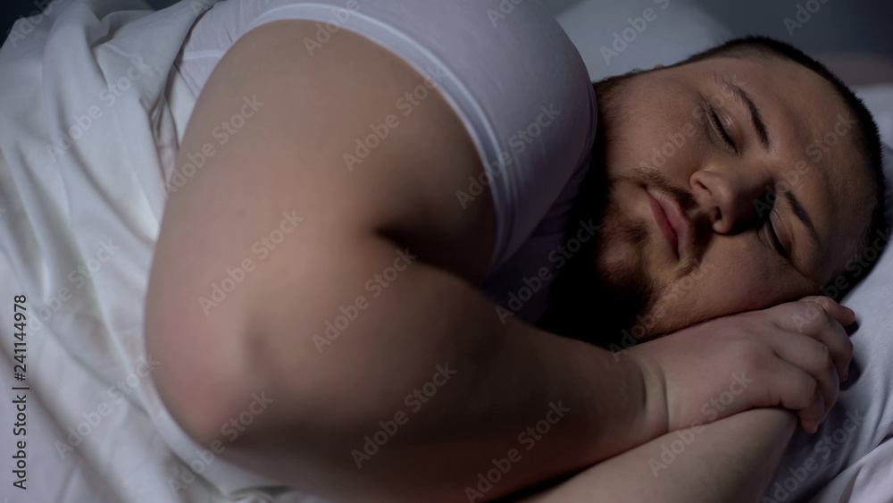 Closeup of obese man sleeping peacefully, relaxing on comfortable mattress