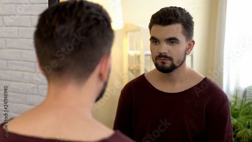 Photography Young male bachelor looking in mirror in morning, appearance insecurities