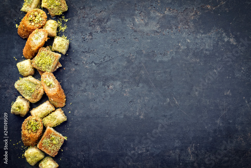 Traditional Oriental baklava collection as top view on a black board with copy space right