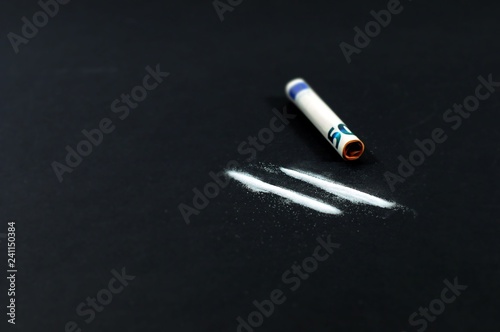 Zwei Linien Kokain und ein aufgerollter 50-Euro-Scheinauf einem schwarzen Tisch
