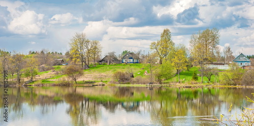 Spring landscape with a village by the river