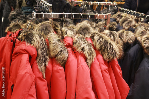 red jackets with a fake fur collar hanging in a row