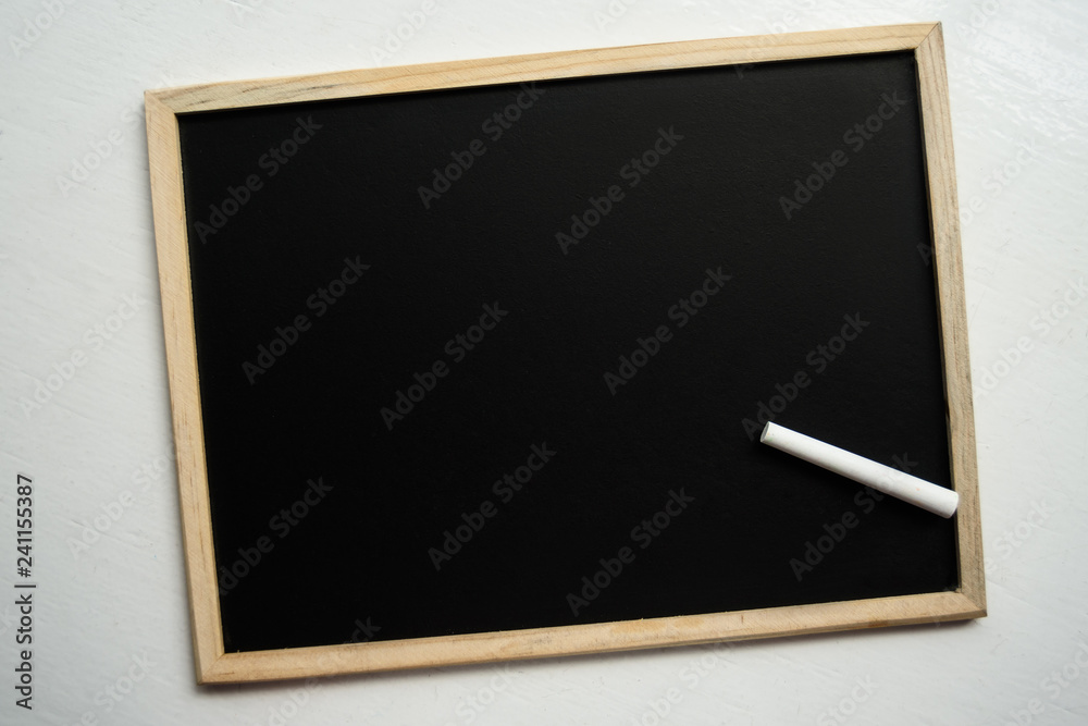 View from top on blackboard with single white round chalk View from top on blackboard with single white round chalk