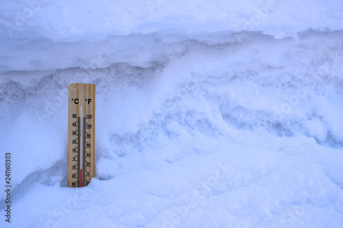 Thermometer inserted into the white snow, close-up