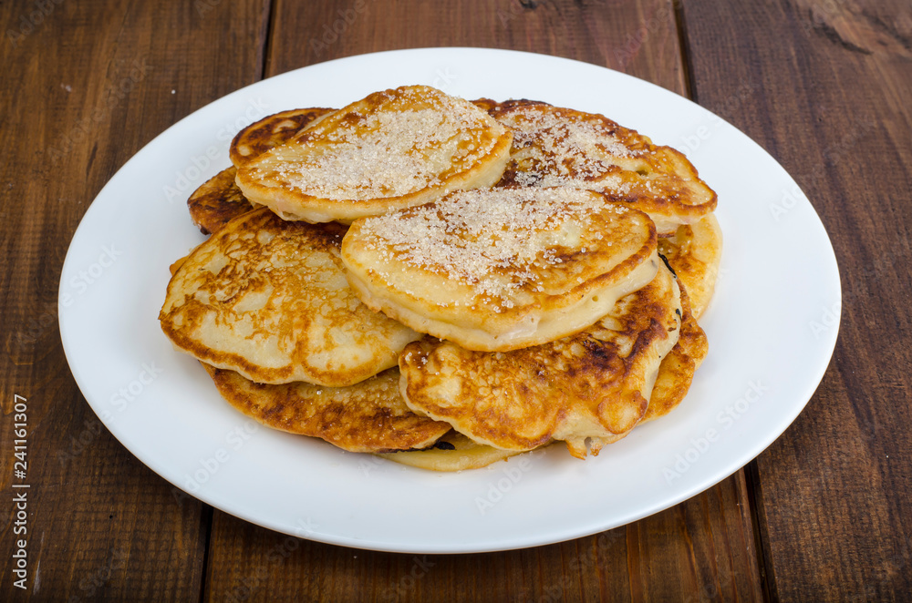 White plate with pancakes on wooden table White plate with pancakes on wooden table