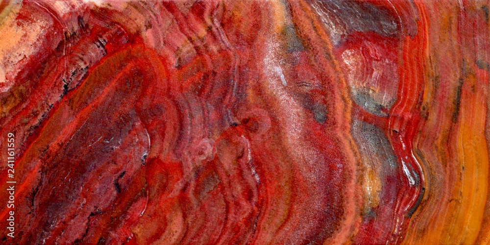 Fototapeta premium Onyx is a variety of agate. The texture of the surface of a beautiful stone. Brown, red, white, yellow color on a semi-precious mineral