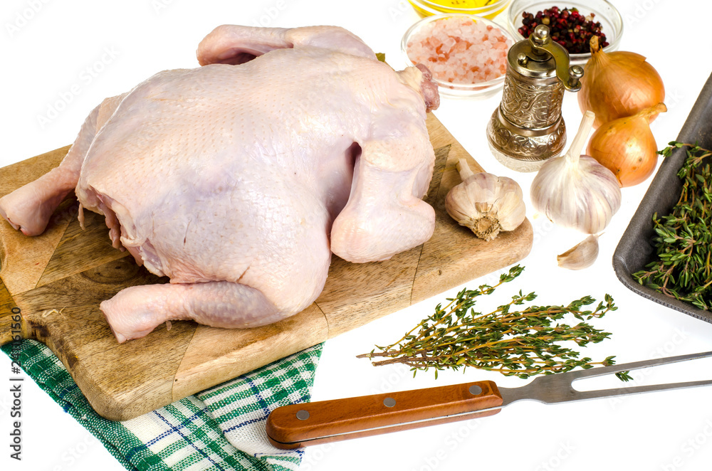Raw chicken meat with vegetables and spices on cutting board, prepared for cooking, white background Raw chicken meat with vegetables and spices on cutting board, prepared for cooking, white background