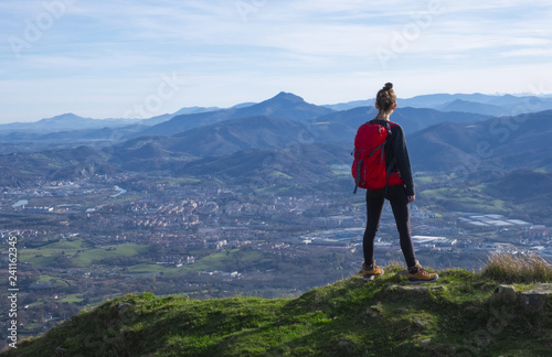 The girl at mountain top. Successful woman backpacker looking at the city. © poliki