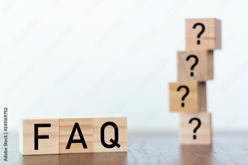 FAQ on wooden blocks with question marks on the background FAQ on wooden blocks with question marks on the background