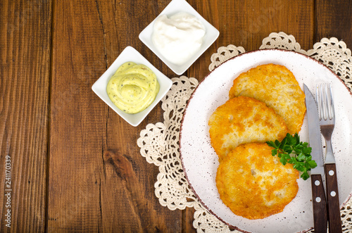 Vegetable rosti, golden fried potato pancakes with dips from cauliflower and sour cream photo