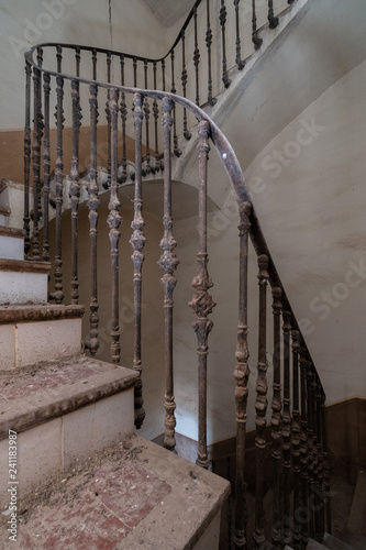 Large stairs with metal railing in abandoned house