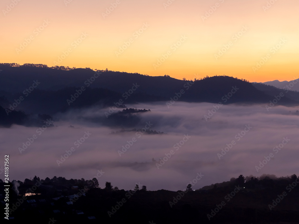 Mountain and foggy at morning time with orange sky, beautiful landscape in the thailand