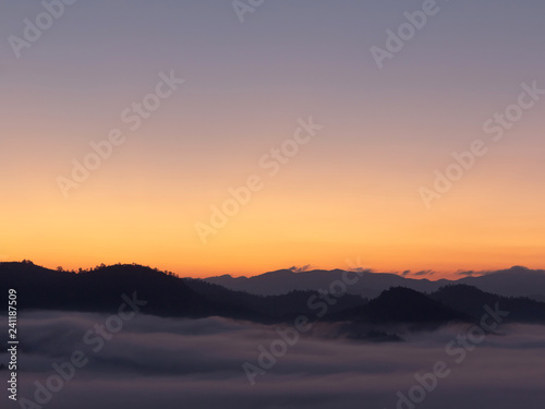 Mountain and foggy at morning time with orange sky, beautiful landscape in the thailand