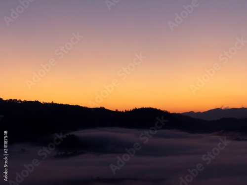 Mountain and foggy at morning time with orange sky, beautiful landscape in the thailand