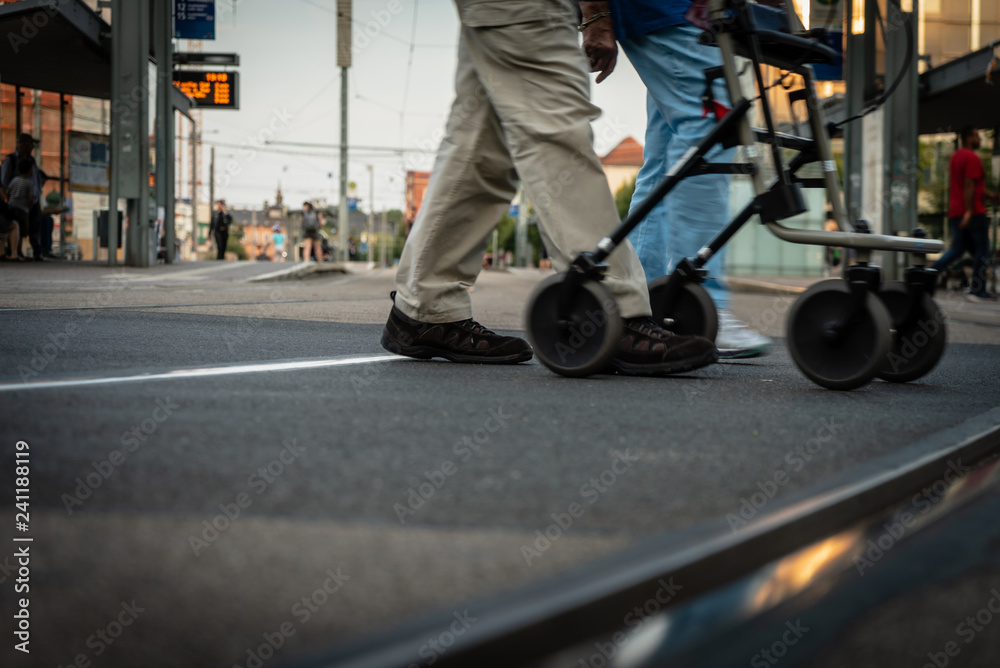 Fototapeta premium Personen mit Rollator überqueren Straße