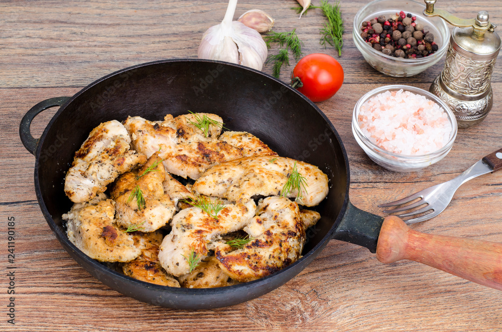 Pan with fried chicken pieces, wooden background