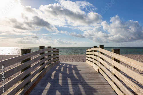 Fototapeta Naklejka Na Ścianę i Meble -  Wooden platform on a sandy beach during a vibrant sunny day. Taken in Sombrero Beach, Marathon, Florida, United States.