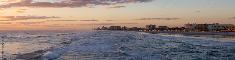 Panoramic view of a beautiful sandy beach during a vibrant sunrise. Taken in Daytona Beach, Florida, United States.