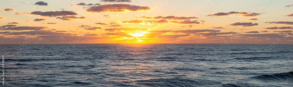 Obraz premium Panoramic view of the ocean during a vibrant cloudy sunrise. Taken in Daytona Beach, Florida, United States.