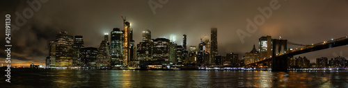 Panoramic view of the Downtown Manhattan and Brooklyn Bridge during a foggy night. Taken in New York  NY  United States.