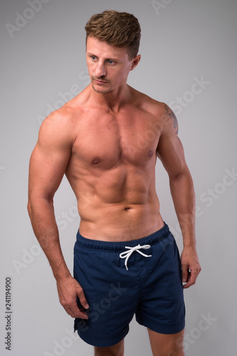 Muscular handsome bearded man shirtless against white background © Ranta Images