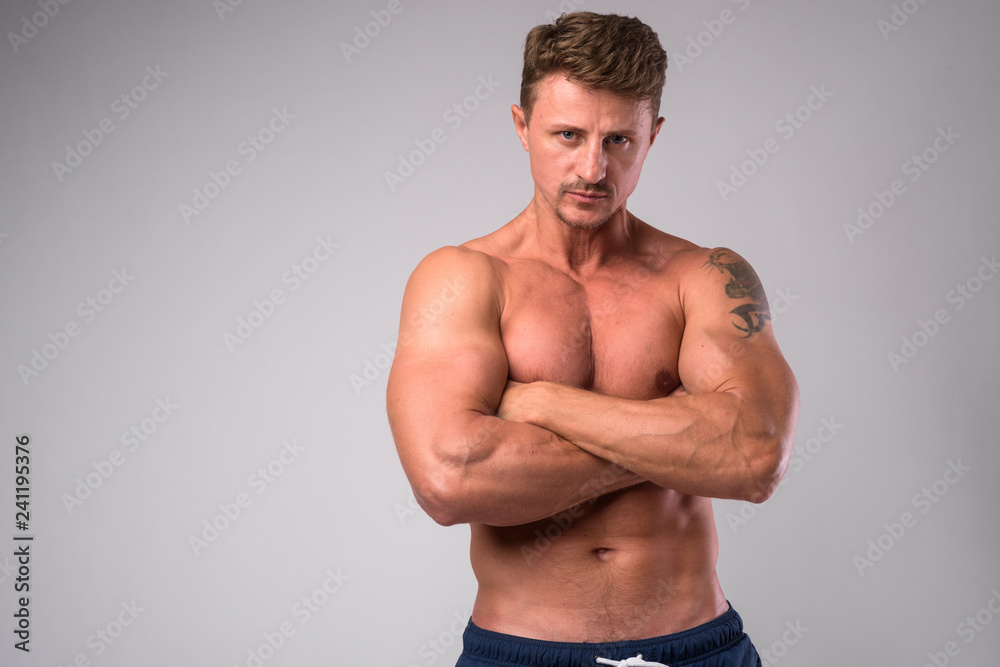 Muscular handsome bearded man shirtless with arms crossed