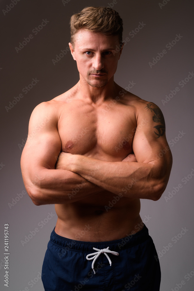 Muscular handsome bearded man shirtless with arms crossed