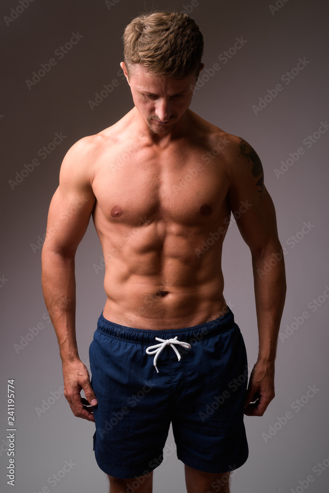 Muscular handsome bearded man shirtless looking down
