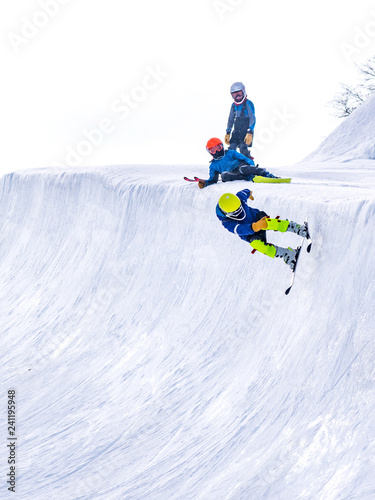 People are enjoying half-pipe skiing	/ snowboarding	 photo