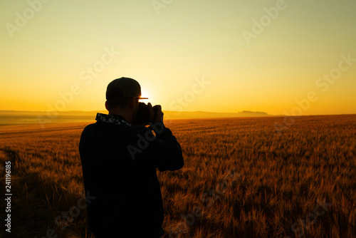 Man take a photo in sunrise in field