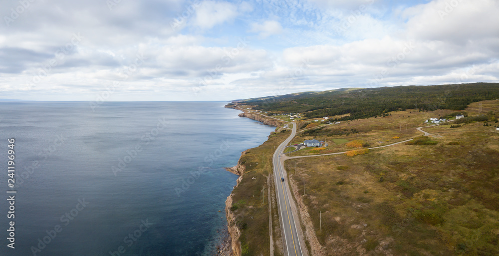 Aerial panoramic landscape view of a scenic road on the Atlantic Ocean Coast during a sunny day. Taken in Port au Port West-Aguathuna-Felix Cove, Newfoundland, Canada. Aerial panoramic landscape view of a scenic road on the Atlantic Ocean Coast during a sunny day. Taken in Port au Port West-Aguathuna-Felix Cove, Newfoundland, Canada.