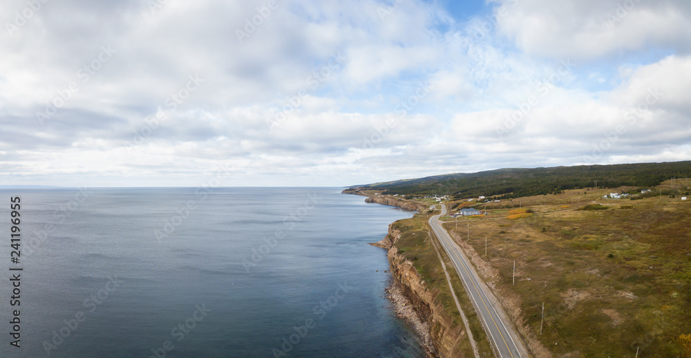 Aerial panoramic landscape view of a scenic road on the Atlantic Ocean Coast during a sunny day. Taken in Port au Port West-Aguathuna-Felix Cove, Newfoundland, Canada.