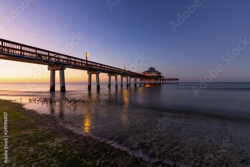 Beautiful view of a wooden Pier on the Atlantic Ocean during a vibrant sunrise. Taken in Fort Myers Beach, Florida, United States. © edb3_16