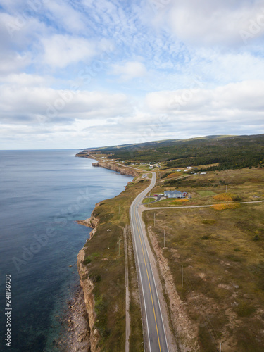 Aerial panoramic landscape view of a scenic road on the Atlantic Ocean Coast during a sunny day. Taken in Port au Port West-Aguathuna-Felix Cove, Newfoundland, Canada.