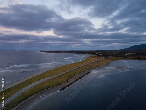 Aerial view of a beach on the Atlantic Ocean Coast during a dramatic sunrise. Taken in Codroy Valley, Newfoundland, Canada.