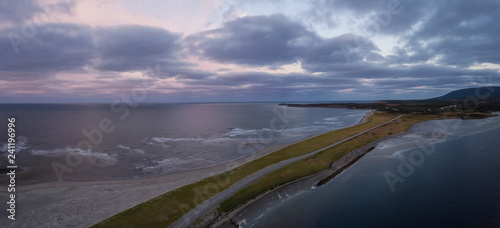 Aerial panoramic view of a beach on the Atlantic Ocean Coast during a dramatic sunrise. Taken in Codroy Valley, Newfoundland, Canada.