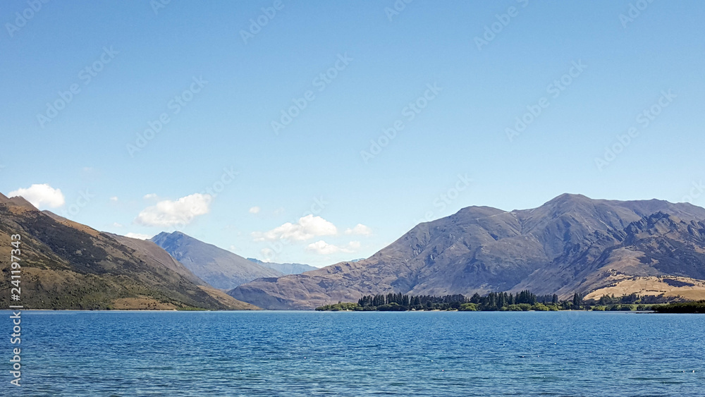 This is a view of Wanaka lake in New Zealand. This is a peaceful place for picnic, relaxing, escaping from work, and nature lovers. The place has clear blue sky, clean and pure lake and mountains.