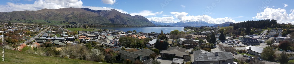 Wanaka is a resort town on New Zealand. This photo was taken on top of Elephant Hill. The view overlooks the entire tourist town of Wanaka. The image has blue sky and mountain.