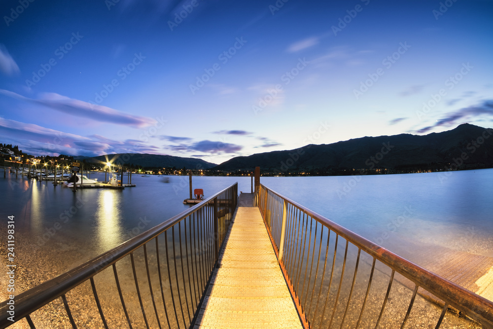 Taken in Wanaka, New Zealand, this harbor dock is a gateway to sail the beautiful lake.