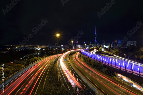 This is a photo taken in Auckland, New Zealand. The road was occupied with cars. It was a very busy night because people are heading in and out of the city center. The lights are very beautiful.