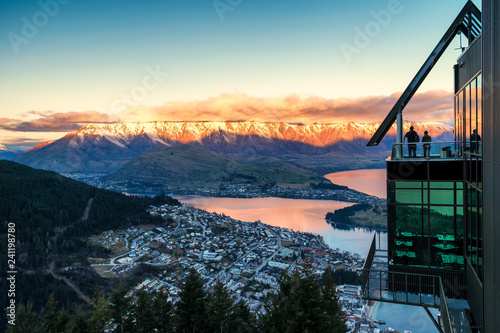 Tourists viewing Queenstown from platform at sunset in New Zealand South Island
