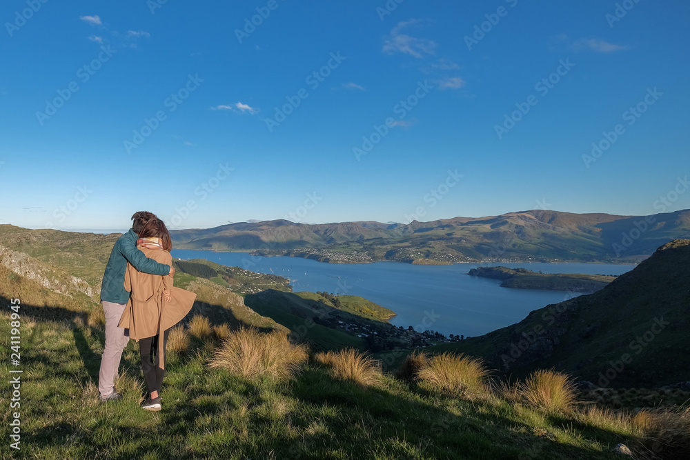 Couple enjoys beautiful port hills Crater Rim near Christchurch in New Zealand. Romantic couple goes on adventure.  Happiness image of a young people going on a day trip.