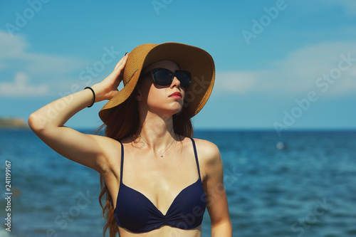 Young woman on a sea vacation . Portrait of a young woman in a swimsuit and hat at a seaside resort © fisher05