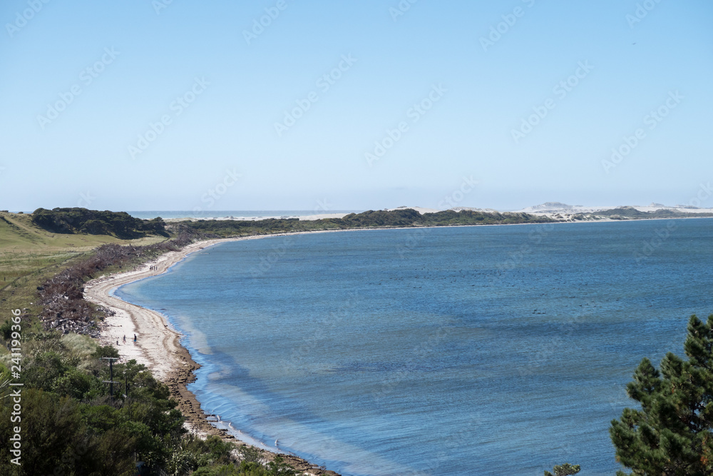 This photo was taken at New Zealand. This coastal region is very beautiful. The beach stretches a long distance. This image is suitable for background use. user can add text on the sky.