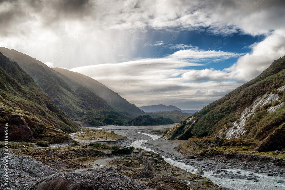 Mountain valley with the river. New Zealand. One can see rain on the left hand side of the breathtaking image. New Zealand south island has many stunning landscape. It is popular tourist destination.