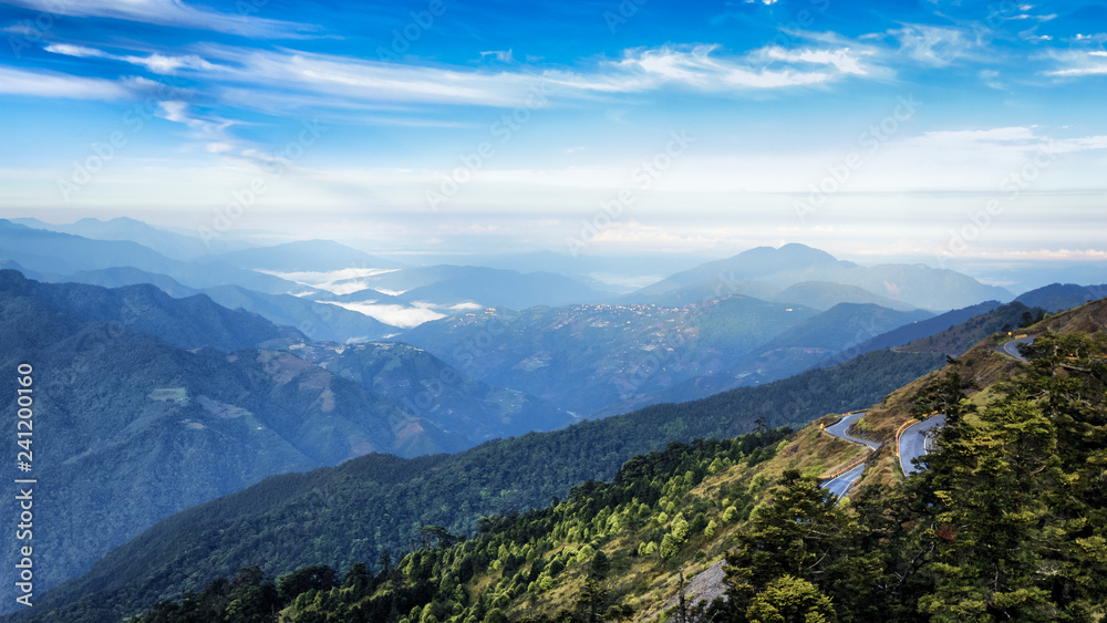 This photo was taken in Taiwan. High up in the mountain, one can see mountain ranges, alpine trees and beautiful cloud formation. One can see really far into the distant. This image is breathtaking.